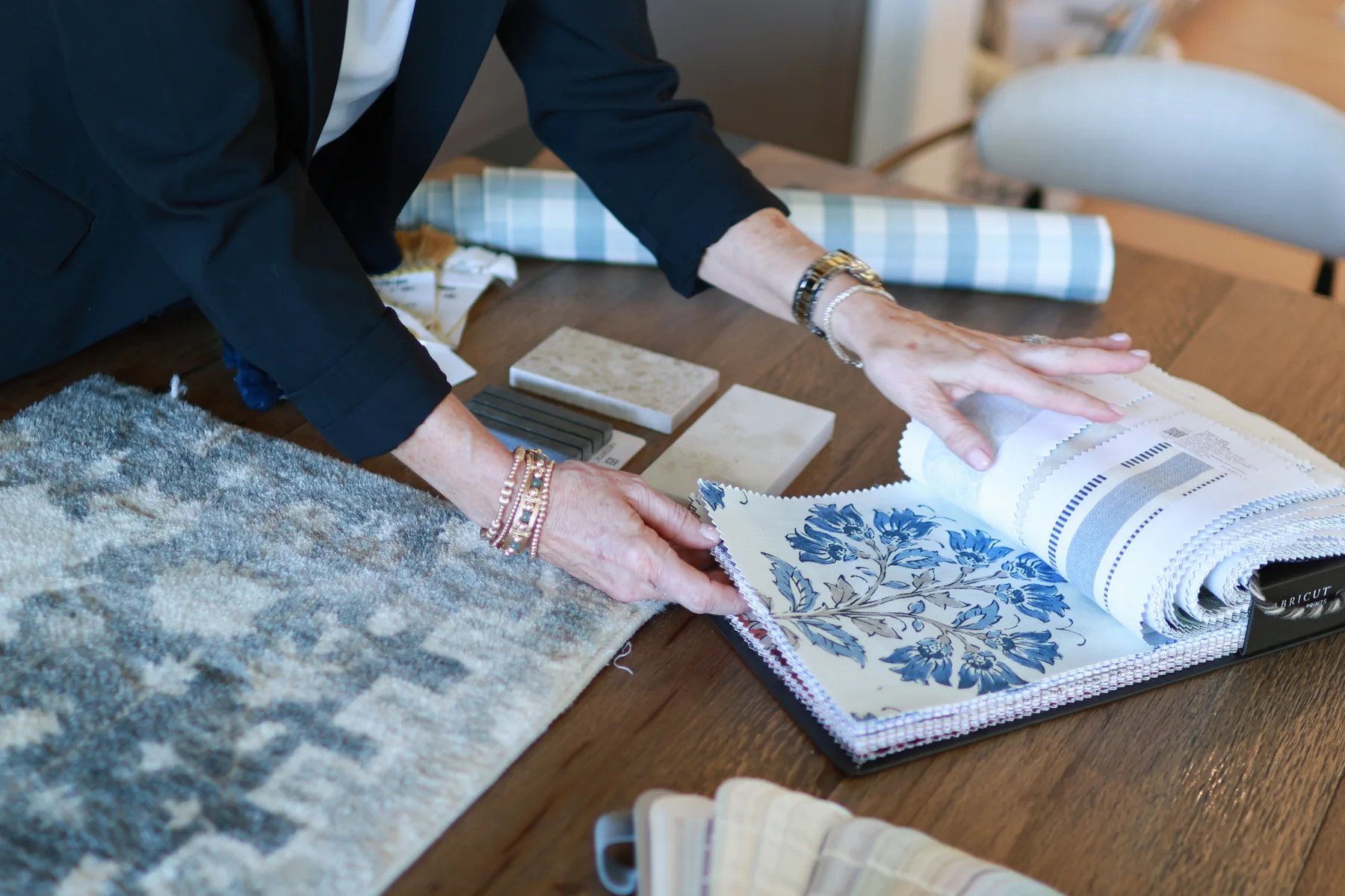 Hands comparing coordinated textile and wallpaper samples