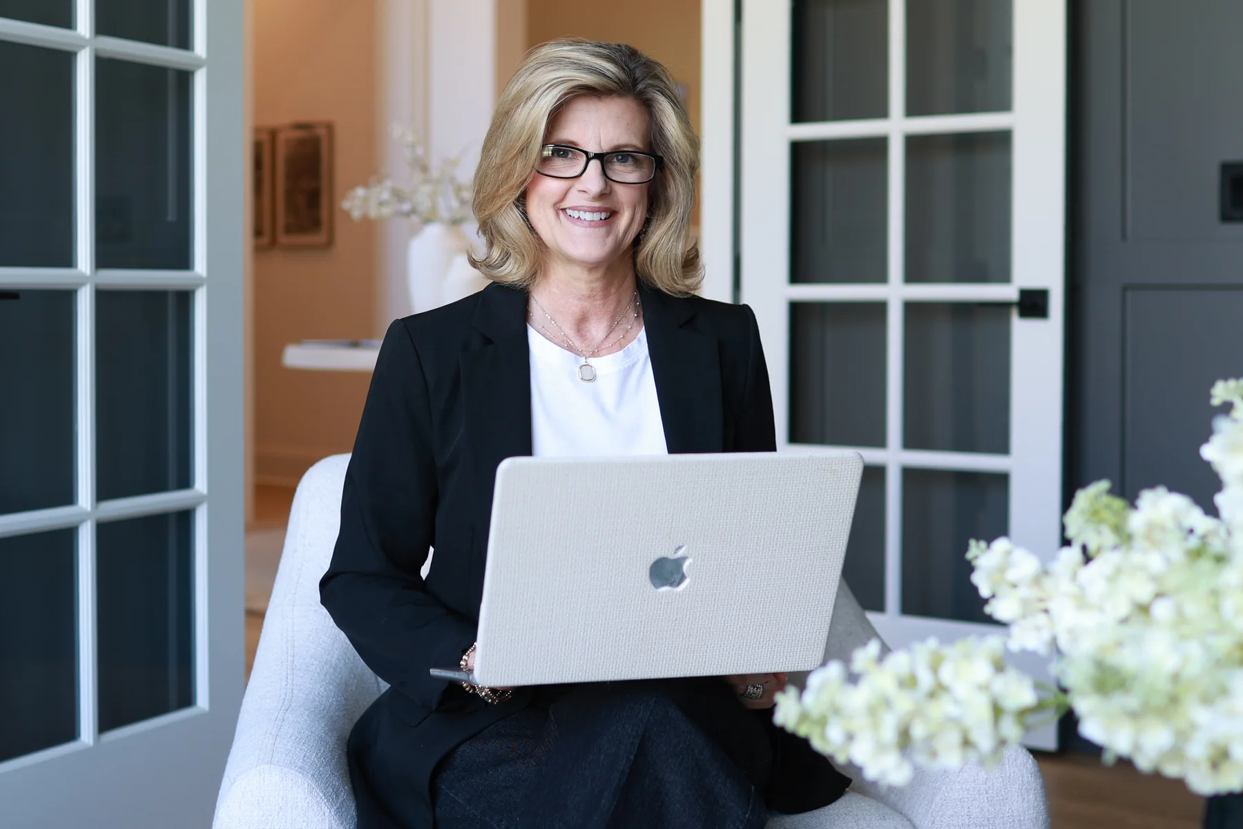 Jennifer Davenport working on a laptop in a bright interior